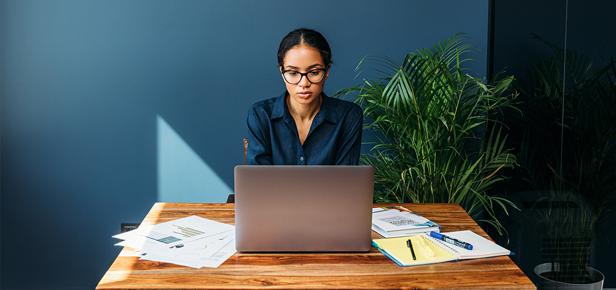 a woman performing tasks on her personal computer and desk
